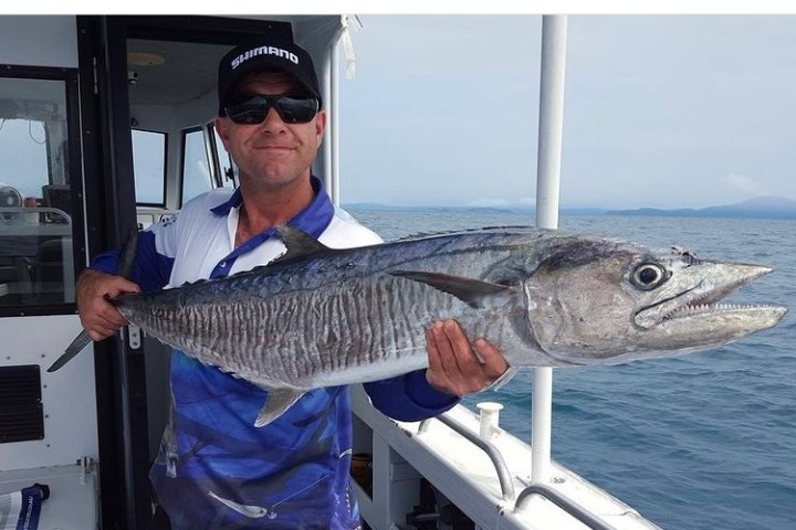 a man holding a fish in the water