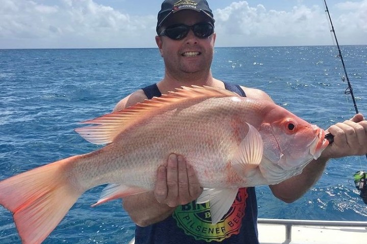 a man holding a fish in the water