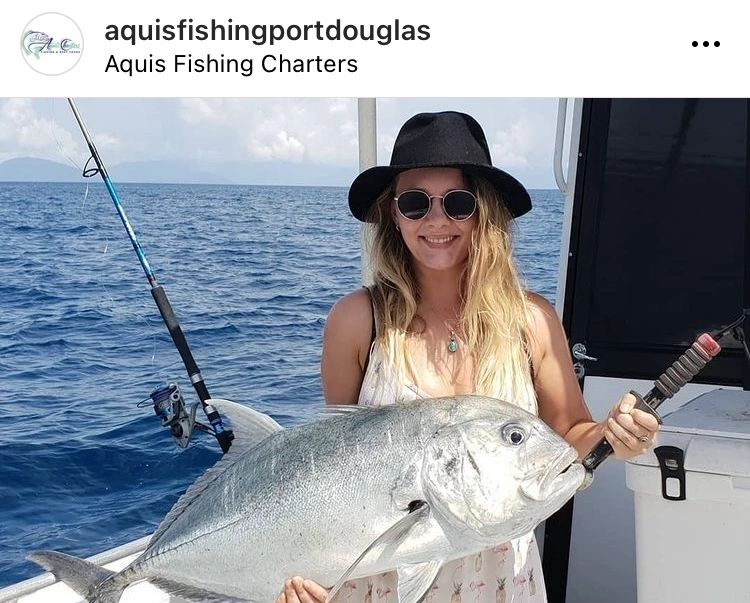 a person holding a fish on a boat