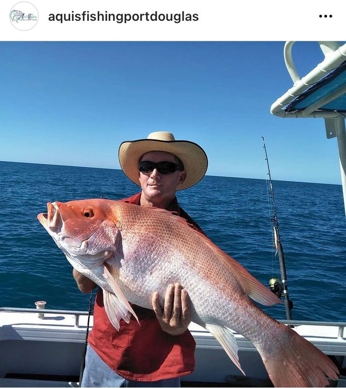 a person holding a fish on a boat in the water