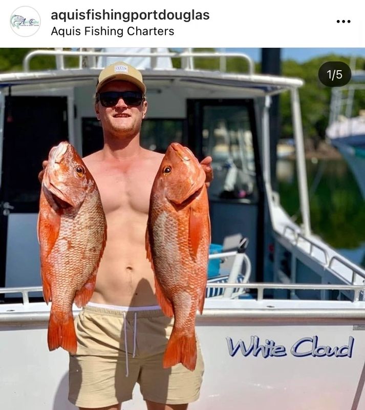 a person holding a fish on a boat