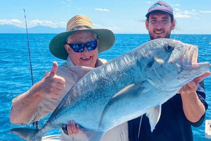 a person holding a fish swimming under water