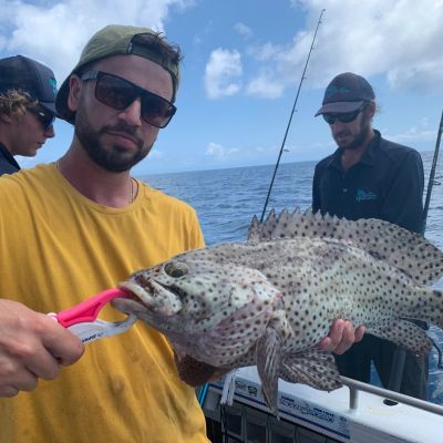 a man holding a fish on a boat