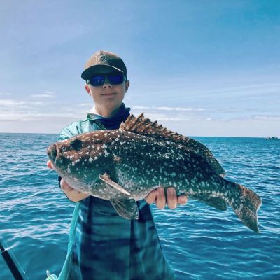 a person standing next to a body of water