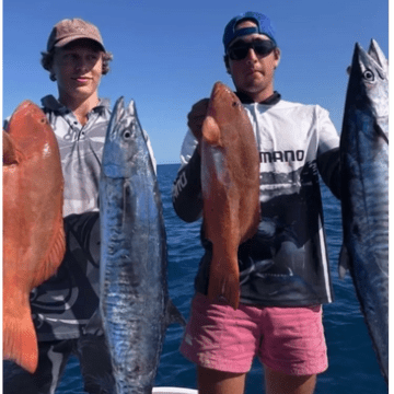 a group of people standing next to a person holding a fish